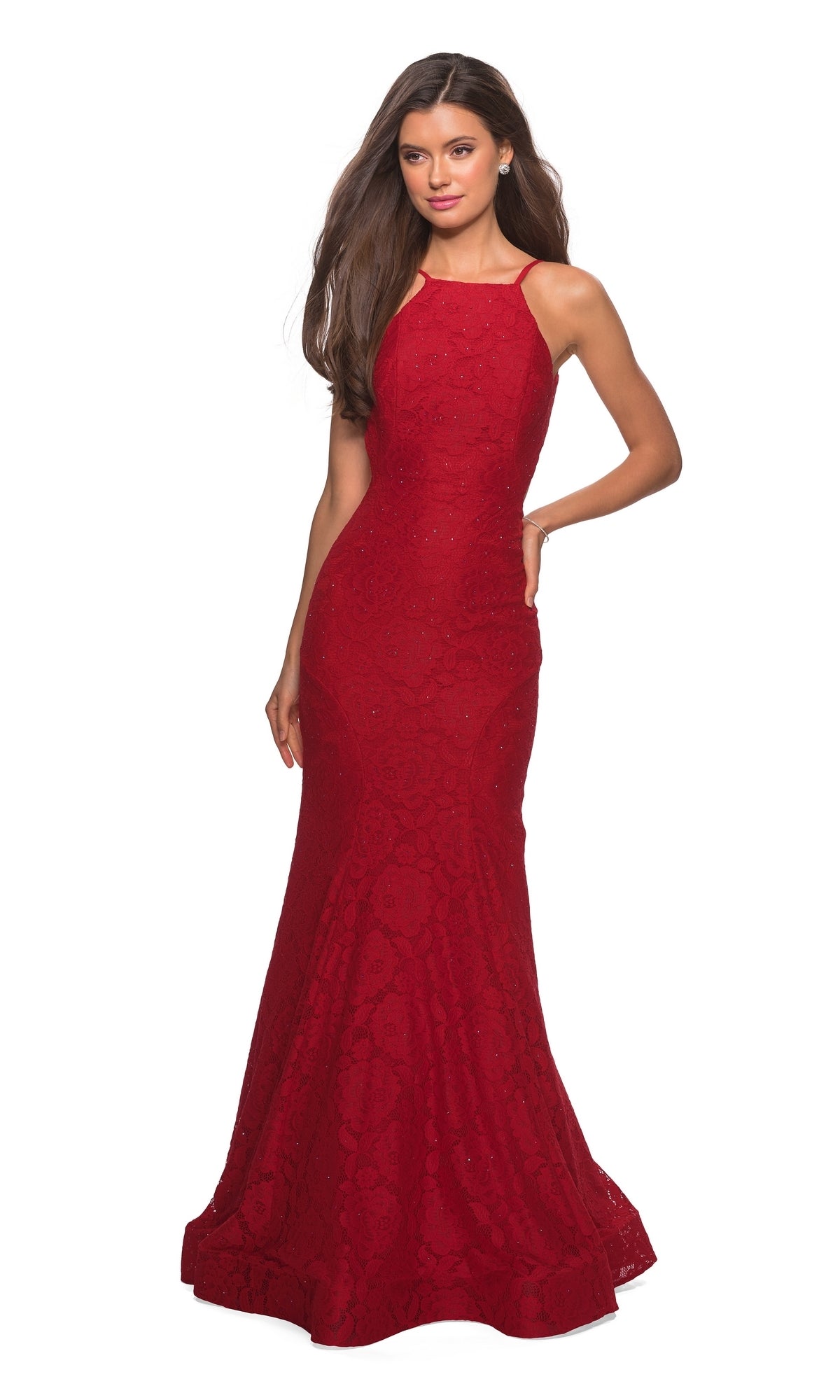 A woman models the La Femme Floral Lace Mermaid Prom Dress 27289, featuring a sleeveless, floor-length design with a fitted bodice, flared hem, and open low v-back, standing confidently with one hand on her hip.
